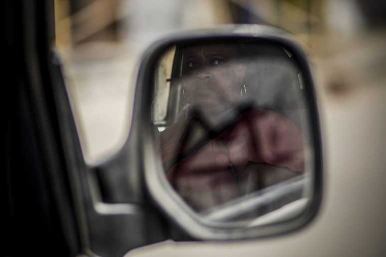 An african woman looks aout of a car window at Tangier, Morocco.