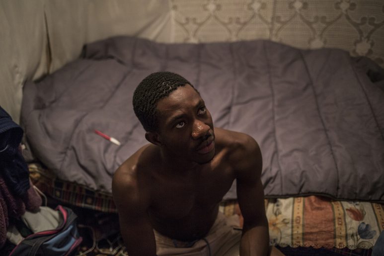 An african migrant sits inside his hut un Nijar, Almeria.